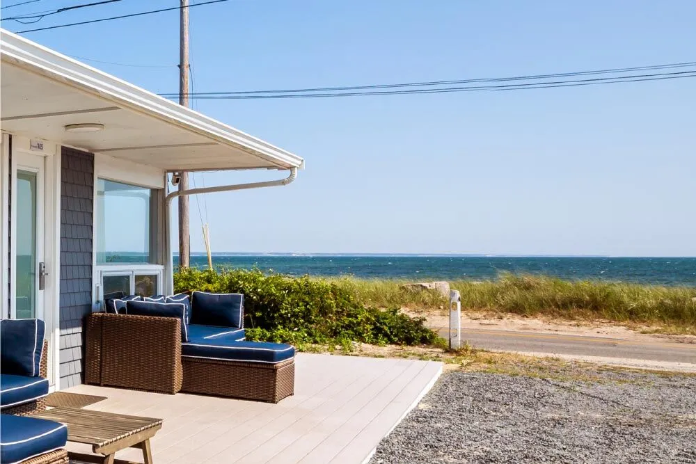 A patio with outdoor furniture overlooking the ocean