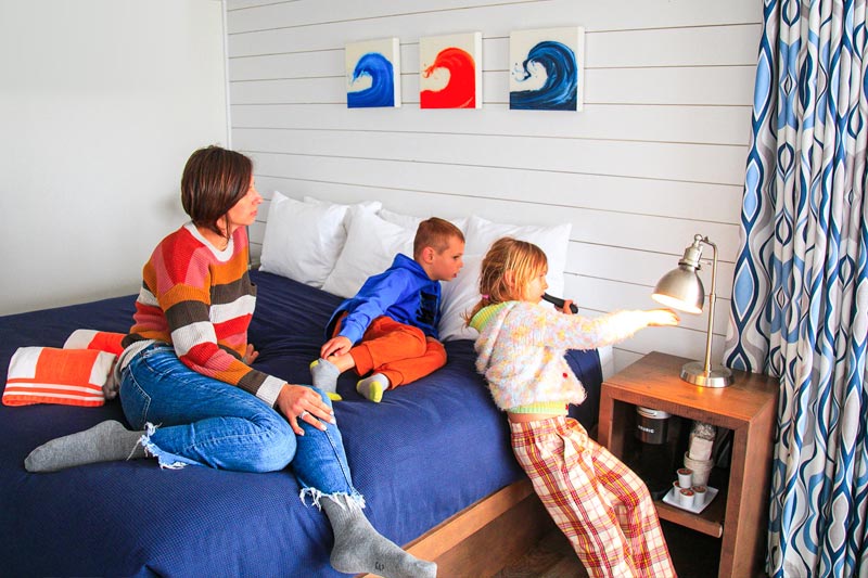Two children and a mom relaxing in a bright bedroom