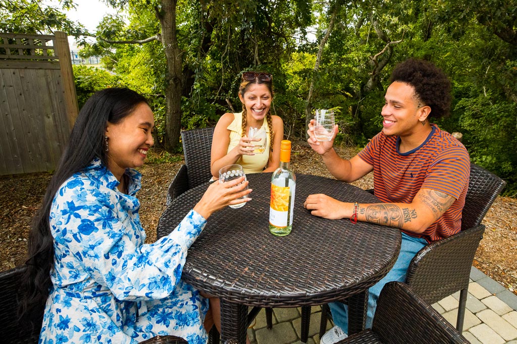 Three young people enjoying wine at an outdoor table