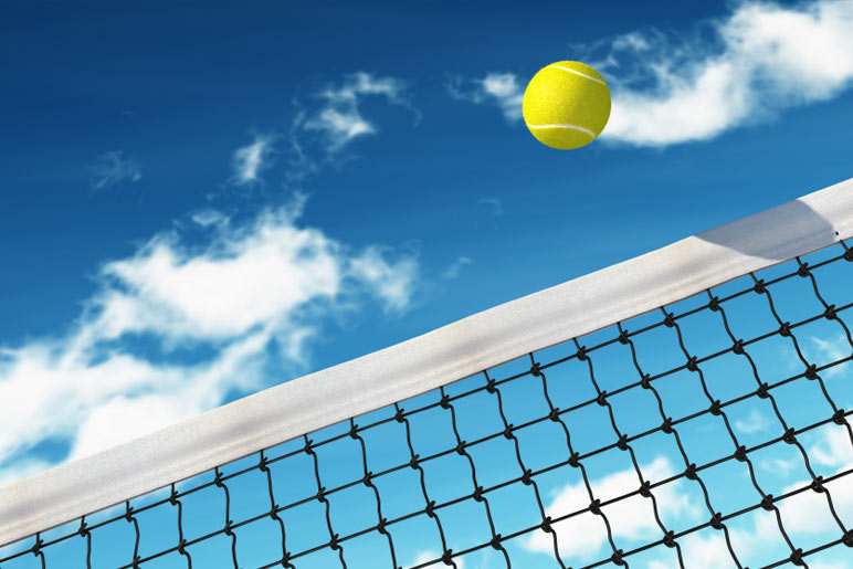 Tennis ball flying over a tennis net